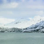 Utsikt over hav og hvite fjell