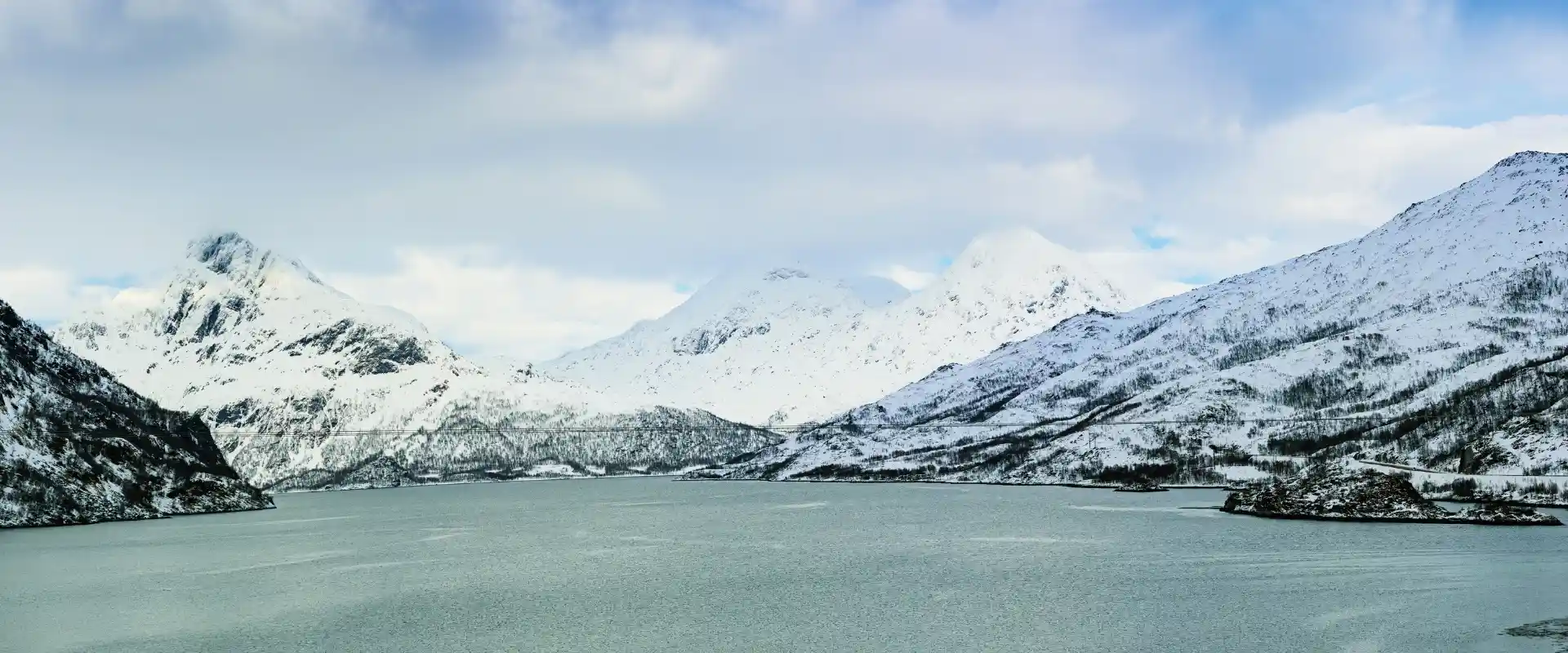 Utsikt over hav og hvite fjell