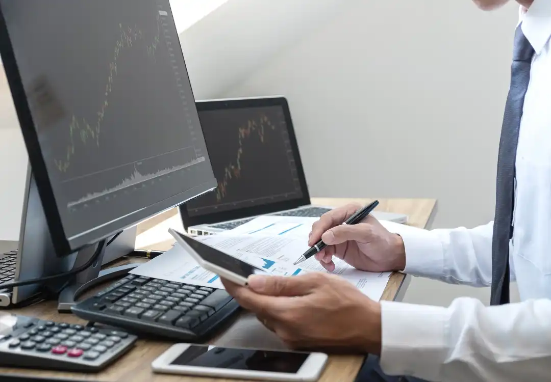 Mann ser på mobil og pc